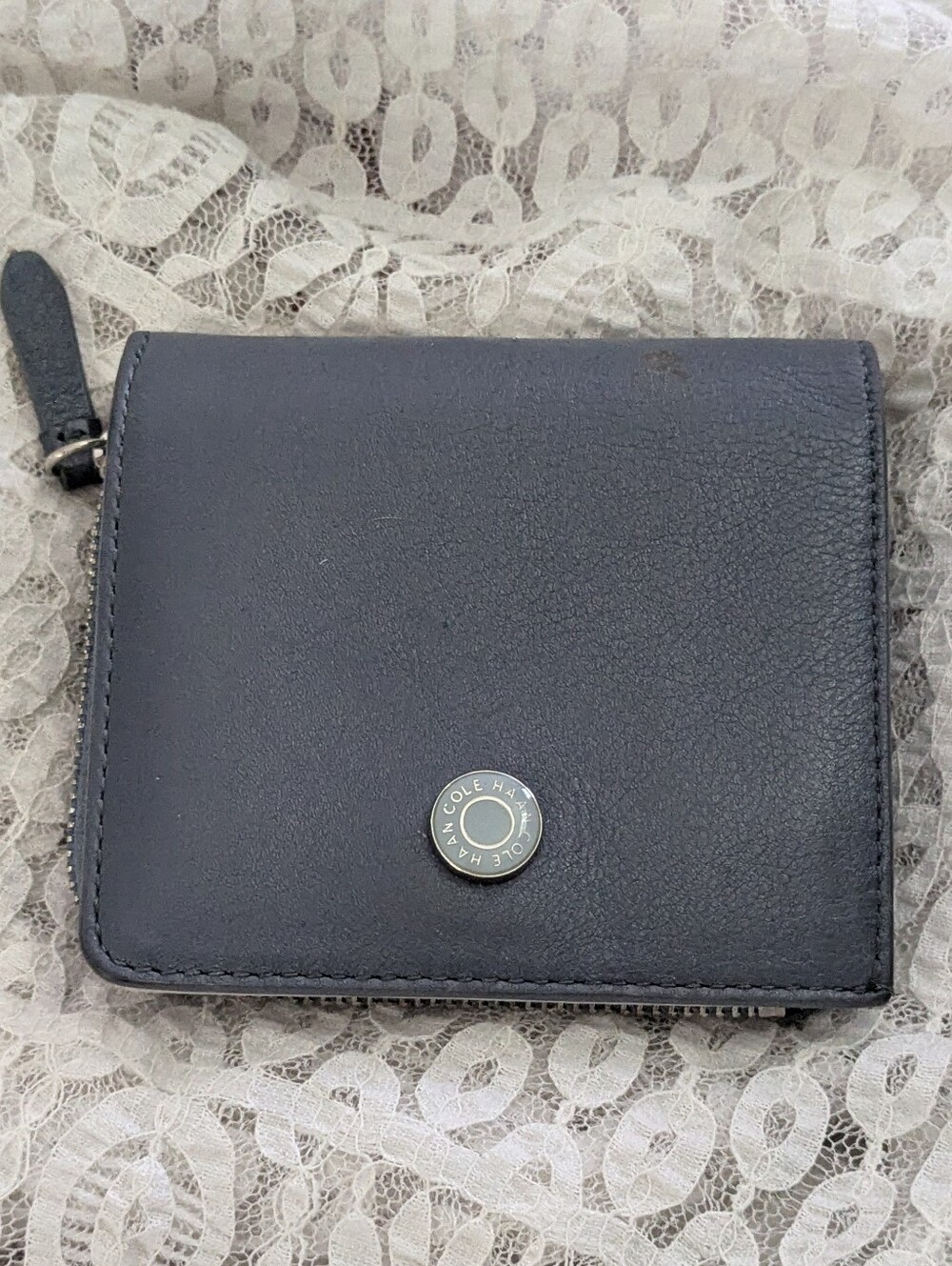Cole Haan leather bifold snap wallet with a side zipper.